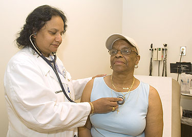 Dr. Umakanthan using a stethoscope to listen to the patient's lungs